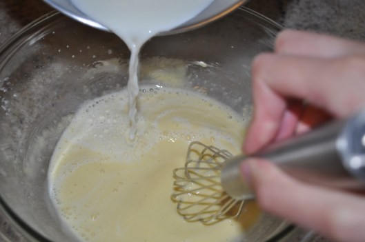 Tempering the milk into the egg mixture