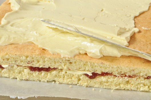 Frosting the raspberry-almond petit fours with rose buttercream